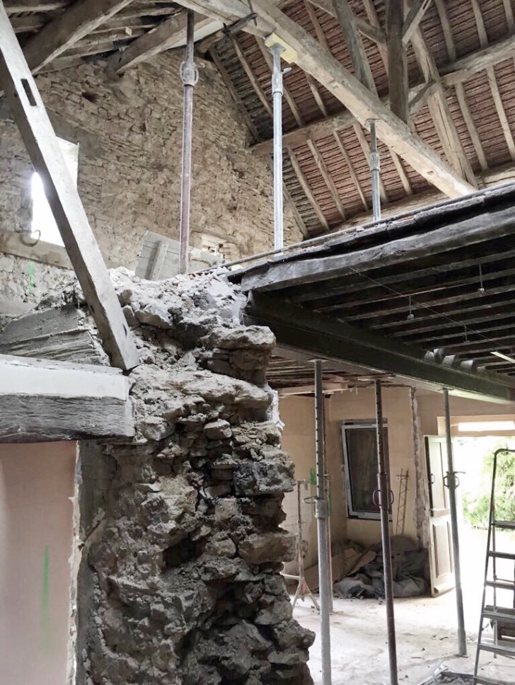 Mur en pierre apparent, charpente d'une maison ancienne en rénovation